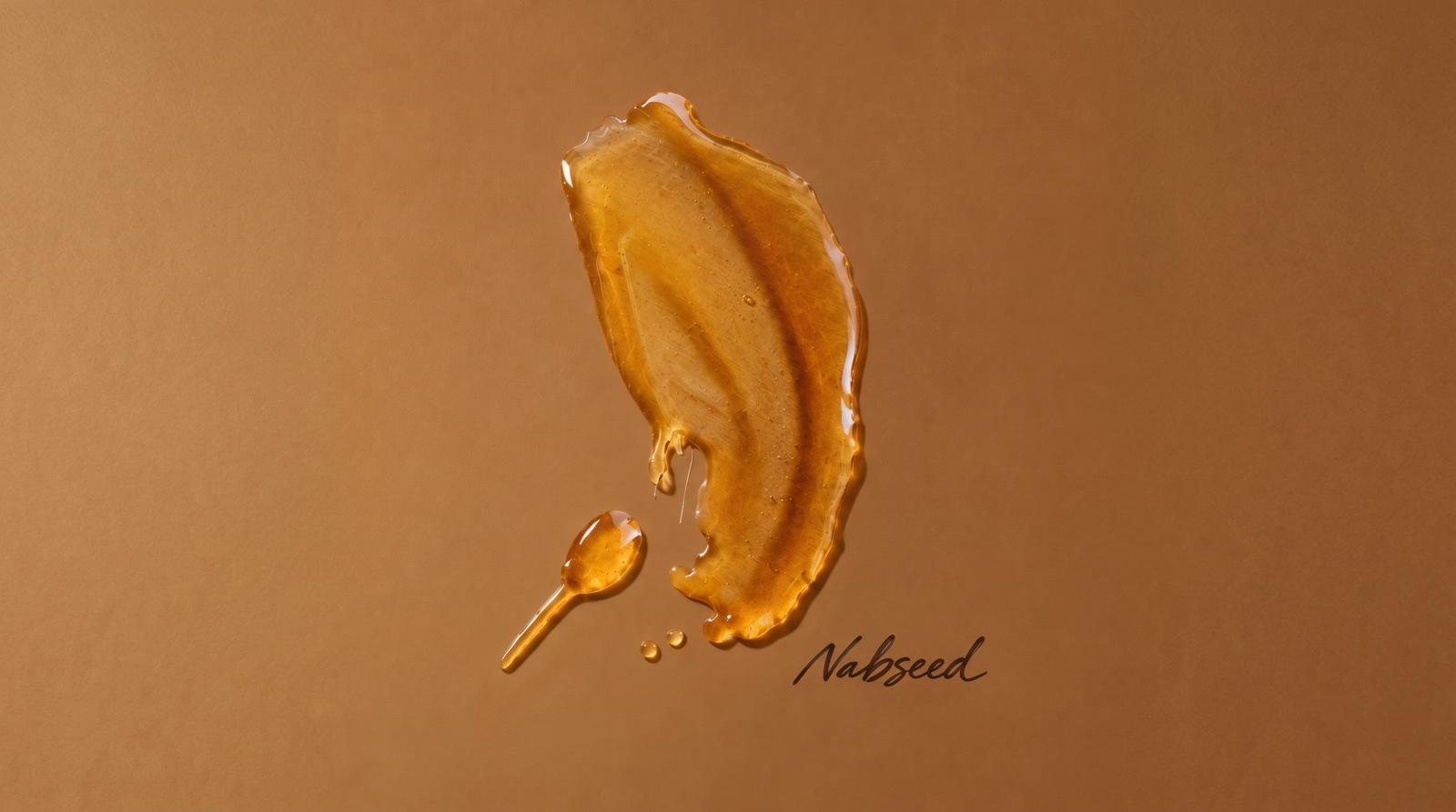 A smear of dark amber honey and a small spoon, signed Nabseed